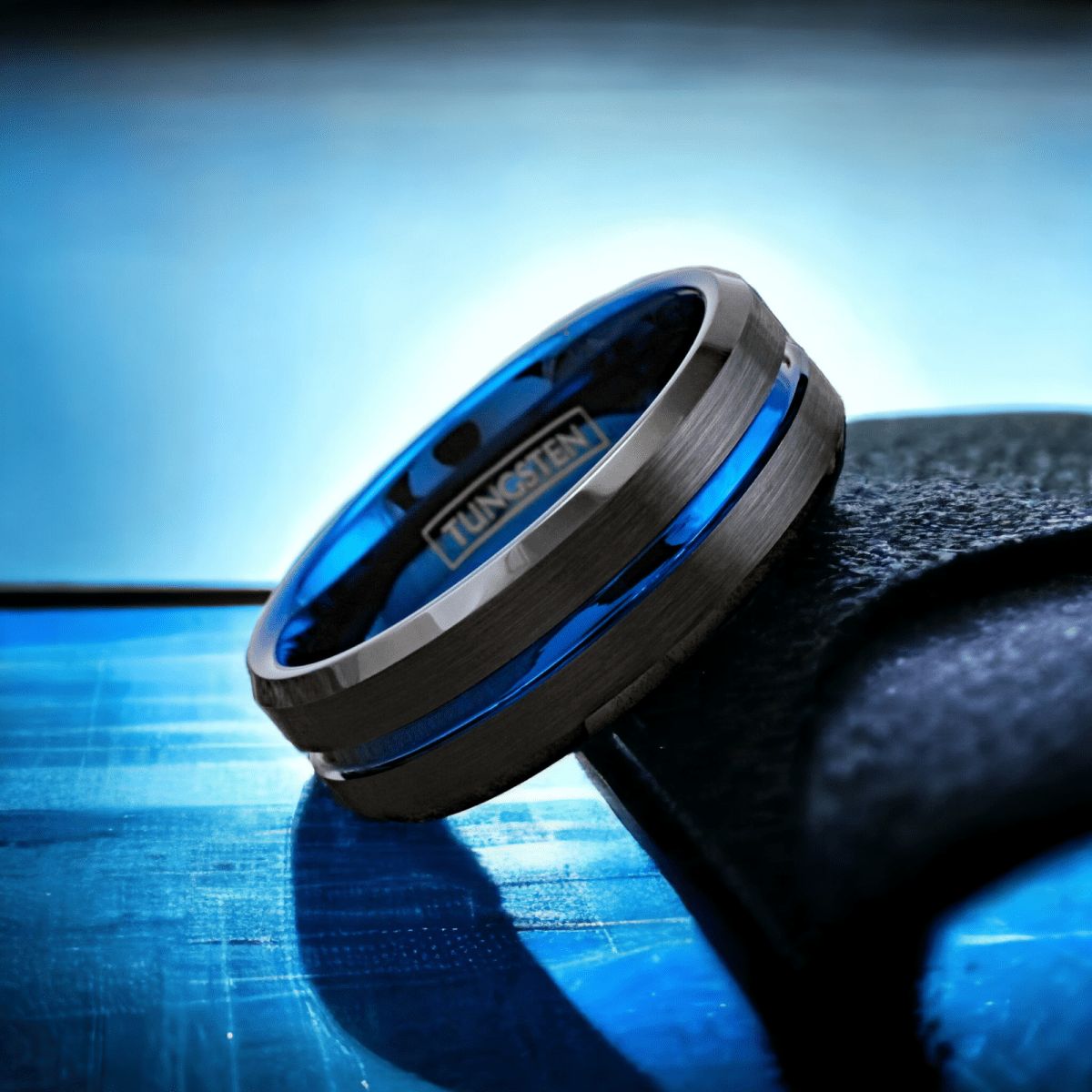 blue and black tungsten wedding ring with beveled edges and a blue inner sleeve.